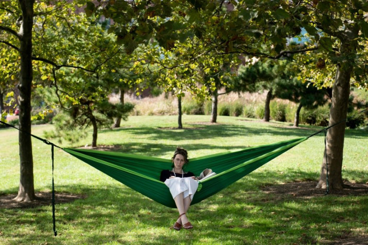 Cait McKay sits in a hammock in Baltimore's Canton neighborhood, one of the city's wealthiest areas