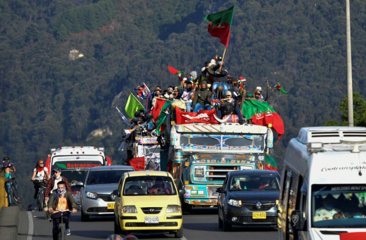 Colombian indigenous people arrive in Bogota on "chivas" (local transport vehicles) on October 18, 2020 to demand a meeting with Colombian President Ivan Duque
