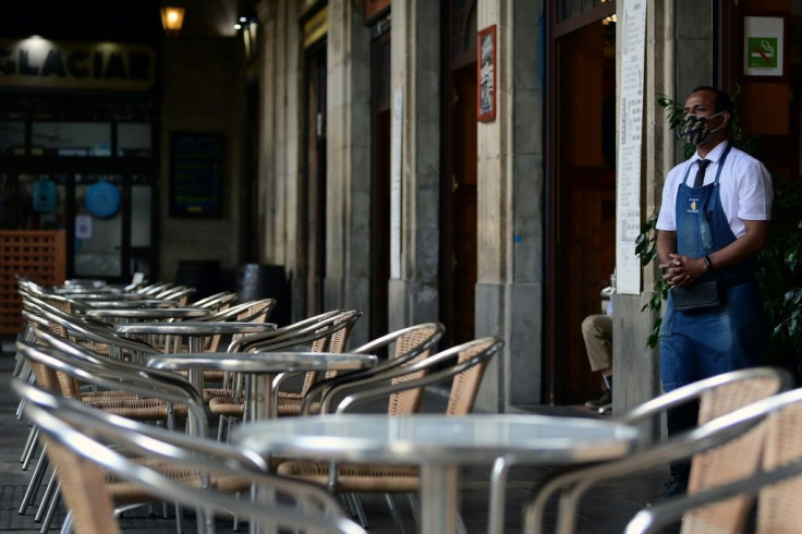 Empty tables at a restaurant in Barcelona, as coronavirus restrictions bite in Spain's two regional economic powerhouses