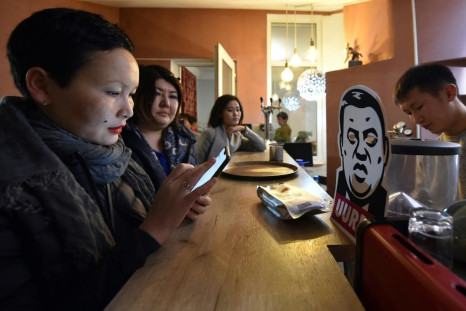 People drink beverages next to a cardboard cut-out depicting Rayimbek Matraimov at an anti-corruption cafe in Bishkek in 2019