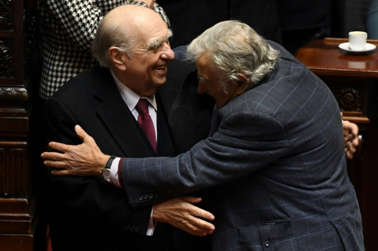 Uruguayan former presidents Julio Sanguinetti (left) and Jose Mujica embrace during their last session as senators at the Congress in Montevideo on October 20, 2020