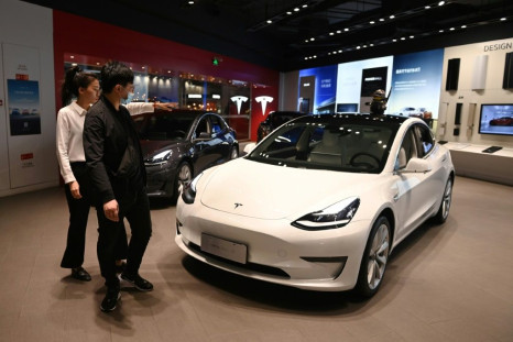 A man looks at a Tesla Model 3 in a Tesla showroom in Beijing on October 21; the electric car giant reported a doubling of profits on robust sales growth