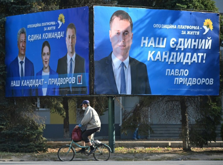 Ahead of Sunday's local elections, a man cycles by a campaign billboard for the Opposition Platform â For Life mayoral candidate Pavlo Pridvorov in Slovyansk, close to the frontline with Russia-backed separatists in eastern Ukraine