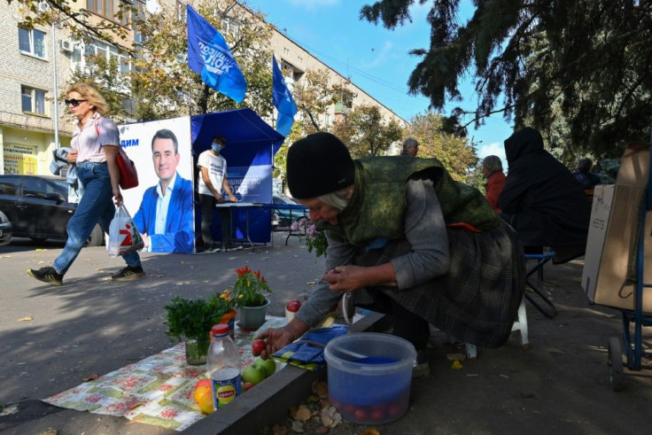 A woman sells fruit and vegetables on a street near a campaign tent of the Opposition Bloc mayoral candidate, current Slovyansk mayor Vadim Lyakh, ahead of October 25 local elections.