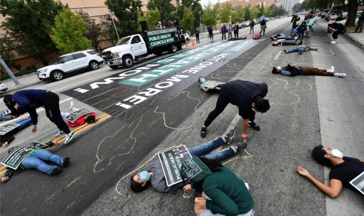 Essential workers, members of the clergy, parents and activists participate in a 'die-in' and memorial service to honor those who have died of Covid-19 in Los Angeles