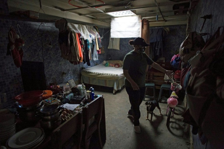 Carla is seen at the room where she lives with her daughters and her father, which used to be a bathroom, at a shelter located in the basement of the Sudameris public building in Caracas
