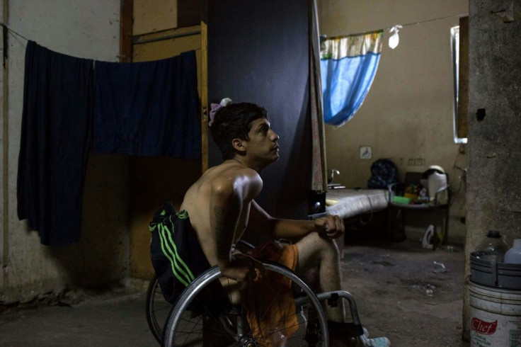 Johan Medina sits in his wheelchair by his room at a shelter located in the basement of the Sudameris public building in Caracas