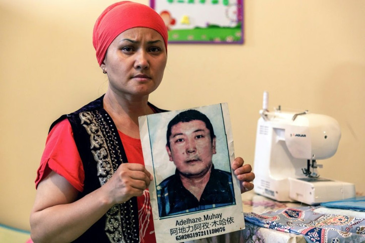 Bikamal Kaken poses with a portrait of her disappeared husband Adilgazy Muqai in Uzynagash