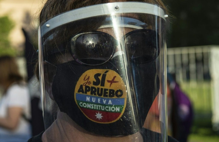 A woman with a face mask reading 'Yes, I do approve the new constitution' takes part in a rally in support of amending the charter established under the military rule of General Augusto Pinochet