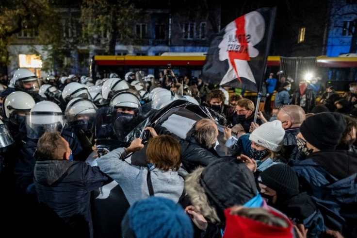 Protestors scuffle with riot police guarding the house of Jaroslaw Kaczynski, leader of Poland's ruling Law and Justice party (PIS)