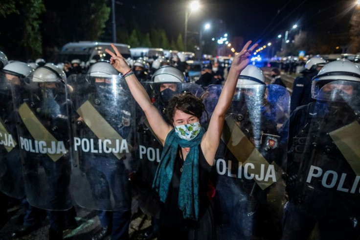 A protester in front of riot police guarding the house of Jaroslaw Kaczynski, leader of Poland's ruling Law and Justice party (PIS) on Wednesday