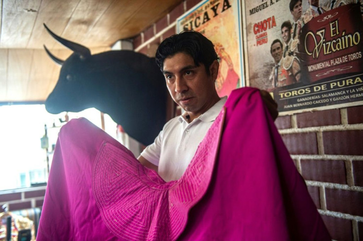 Bullfighter Fernando Villavicencio shows off the cloak he uses in corridas
