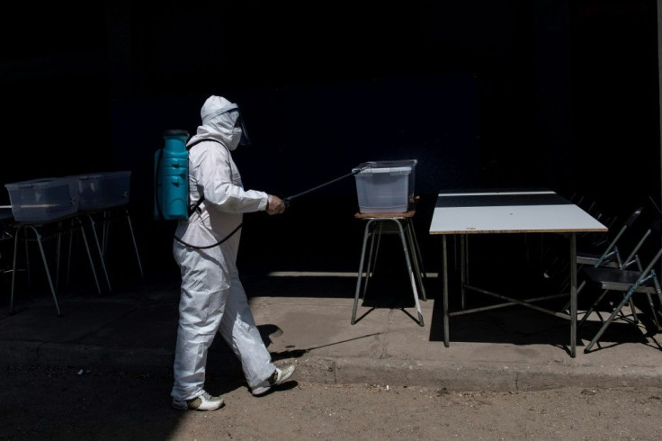 A worker disinfects a polling station on the eve of Chile's constitutional referendum