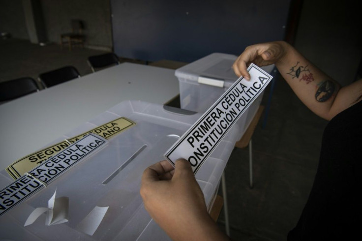 An electoral worker sets up a polling station on the eve of Chile's constitutional referendum in Santiago