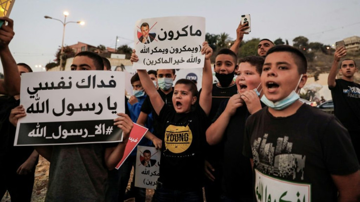 Arab Israeli Muslim demonstrators, clad in masks due to the COVID-19 coronavirus pandemic, protest against the comments by French President Emmanuel Macron, in the Arab town of Umm-Al Fahem in Northen Israel on Sunday