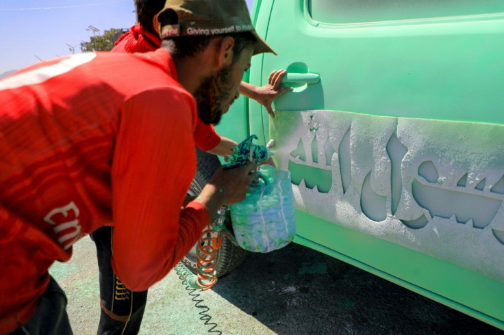 A Yemeni man sprays 'At your orders, Oh messenger of Allah' on a truck in the capital Sanaa on Saturday, as the backlash against Macron grew