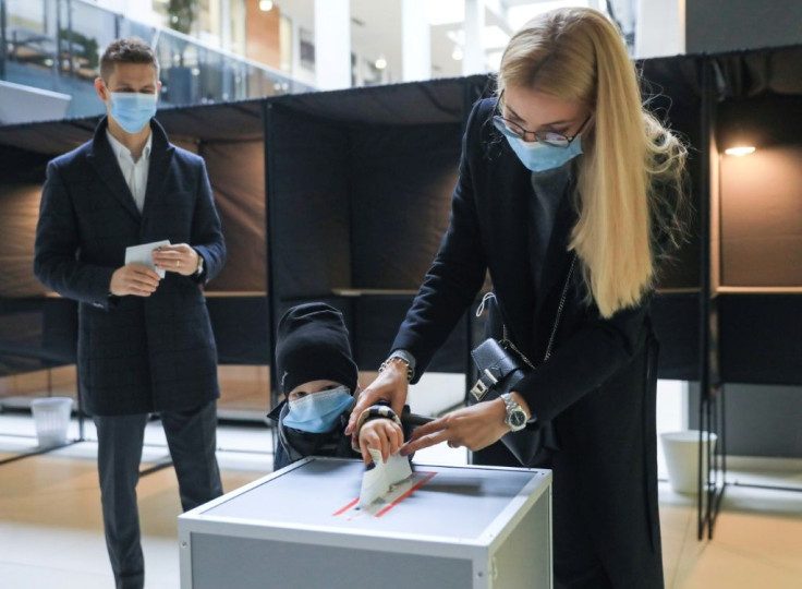 A woman and a child cast a ballot during the second round of the parliamentary elections in Lithuanian capital Vilnius