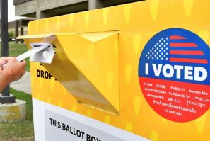 A voter drops a ballot for the 2020 US elections into an official drop box in Norwalk, California