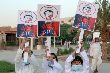 Kuwaiti youths brandish placards expressing anger at French President Emmanuel Macron