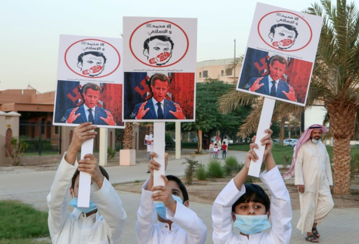 Kuwaiti youths brandish placards expressing anger at French President Emmanuel Macron