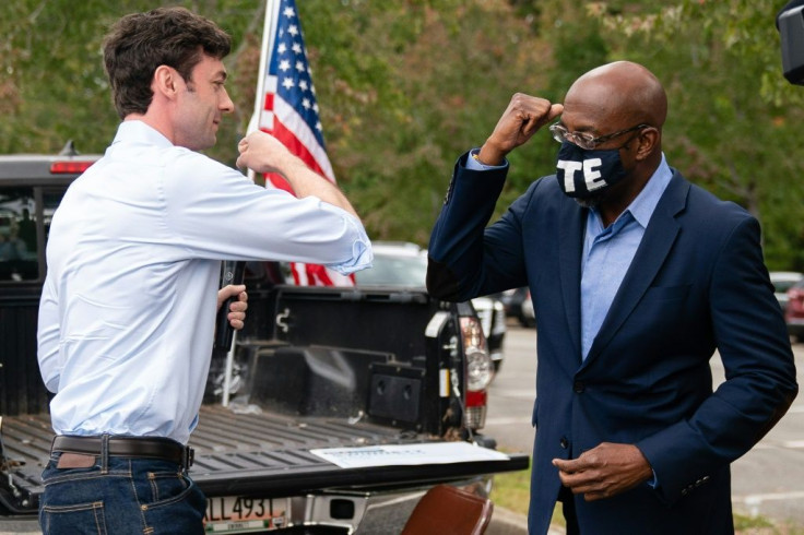 Democratic Senate candidates Jon Ossoff (L) and Rev. Raphael Warnock (R) bump elbows at a rally in Duluth, Georgia