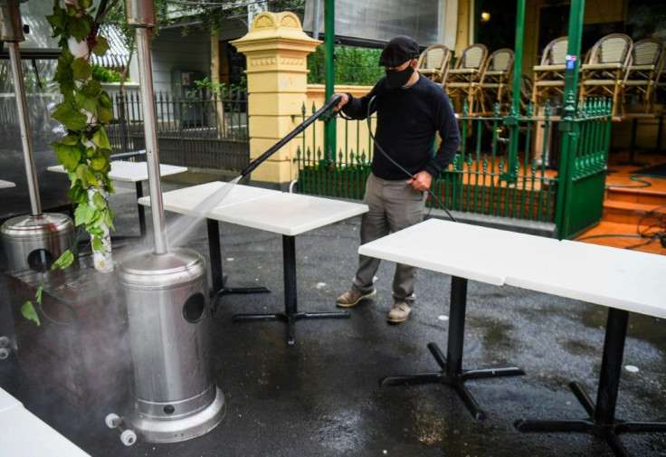 A man cleans as restaurants and cafes prepare for opening in Melbourne on October 27, 2020, as the state government lifts some restrictions on retail and restaurants after the city battled a second wave of the Covid-19 coronavirus.