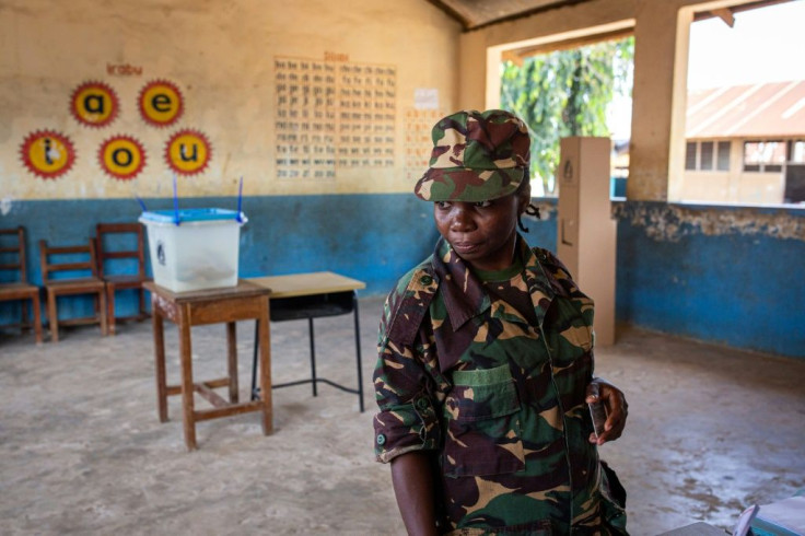 A Tanzanian security officer waits to cast her ballot in early voting