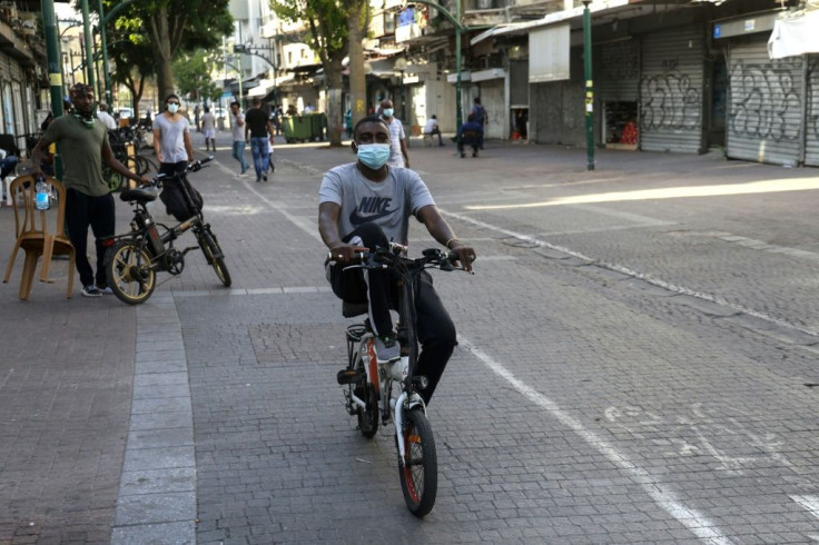 An asylum seeker from Sudan rides his bicycle on a street in southern Tel Aviv, where thousands of Sudanese live