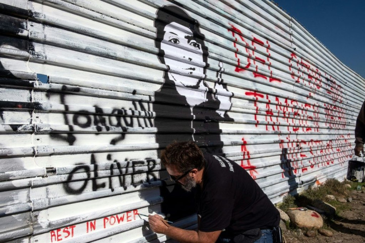 Manuel Oliver, seen on the Mexican side of the border with the US in front of a portrait of his slain son Joaquin