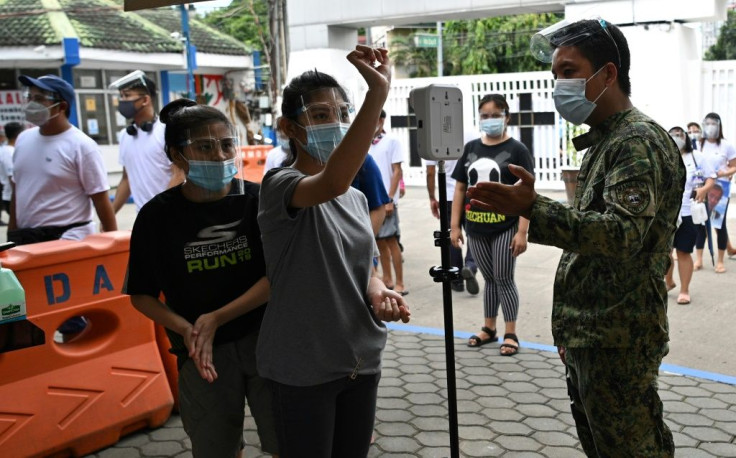 Coronavirus precautions are in place as people in the Philippine capital flock to graveyards ahead of All Saints' Day
