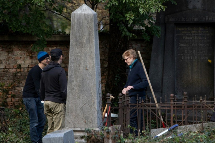 Volunteers including Greens councillor Jennifer Kickert (R) work in the Waehring cemetery