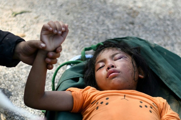 Four-year-old Ho Ha My's hand is held by her mother Ho Thi Ha after she was rescued from a landslide in Tra Leng commune in central Vietnam's Quang Nam province