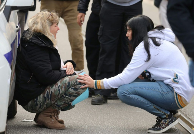 A woman kneels by a police car and cries in Nice after the attack