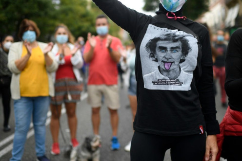 A youth wears a jersey depicting the likeness of Spanish health official Fernando Simon during a demonstration in Madrid against new restrictive measures announced by regional authorities