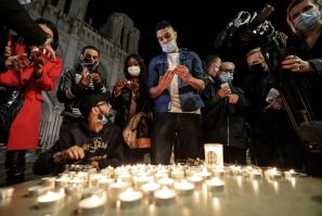 People lights candle outside the Notre-Dame de l'Assomption Basilica in Nice in tribute to the three victims of a knife rampage, which France's president called an 'Islamist terrorist attack'