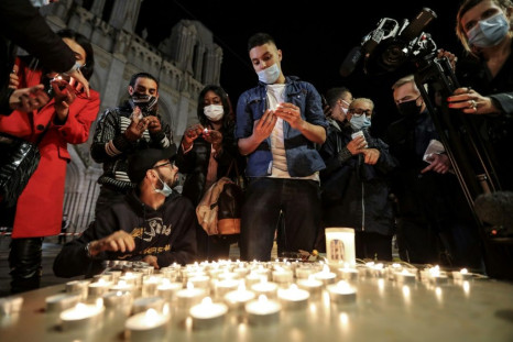 People lights candle outside the Notre-Dame de l'Assomption Basilica in Nice in tribute to the three victims of a knife rampage, which France's president called an 'Islamist terrorist attack'