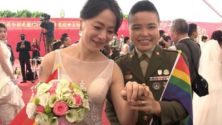 Waving rainbow flags and shedding tears of joy, two Taiwanese same-sex couples tie the knot at a mass wedding hosted by the military in a landmark for Asia's LGBT community.