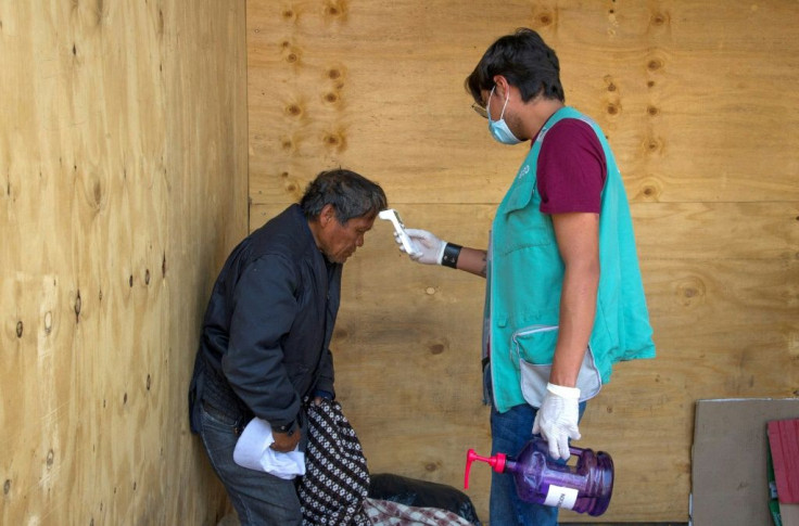 A health worker takes the temperature of a homeless man in Mexico City during the coronavirus pandemic