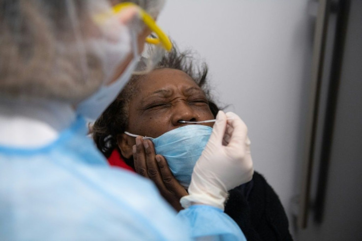 A French pharmacy employee carries out a swab test on a patient