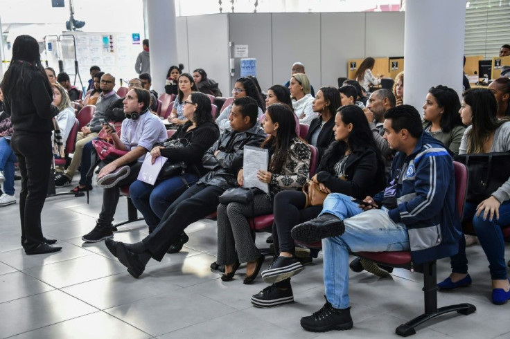 In this file photo taken on June 11, 2019 unemployed people in Brazil wait their turn to get information on job opportunities at the Workers Service Department in Sao Paulo