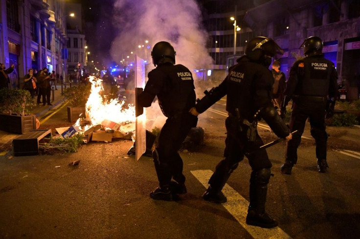 Members of the Catalan regional police force take position next to burning trash set on fire by protesters during a demonstration against new coronavirus restrictions in BarcelonaOne by one, Spain's regions have announced regional border closures.