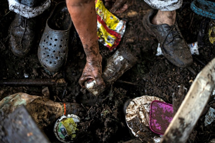 A survivor of a landslide searches through the rubble of his home for belongings in Nejapa, El Salvador on October 30, 2020