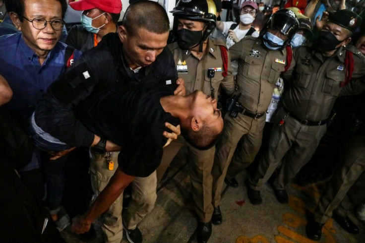 Pro-democracy activist Panupong 'Mike' Jadnok (C) is carried into a hospital vehicle after arriving at Prachachuen police station in Bangkok after a court ordered his release from jail