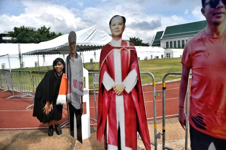 Some Thai university graduates like this woman has their photos taken cardboard cutouts of Thai dissidents