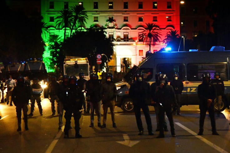 Rome police officers block the road during a protest rally organized by a left-wing movement demanding economic support measures, as the government announced a new series of restrictions to contain the spread of Covid-19