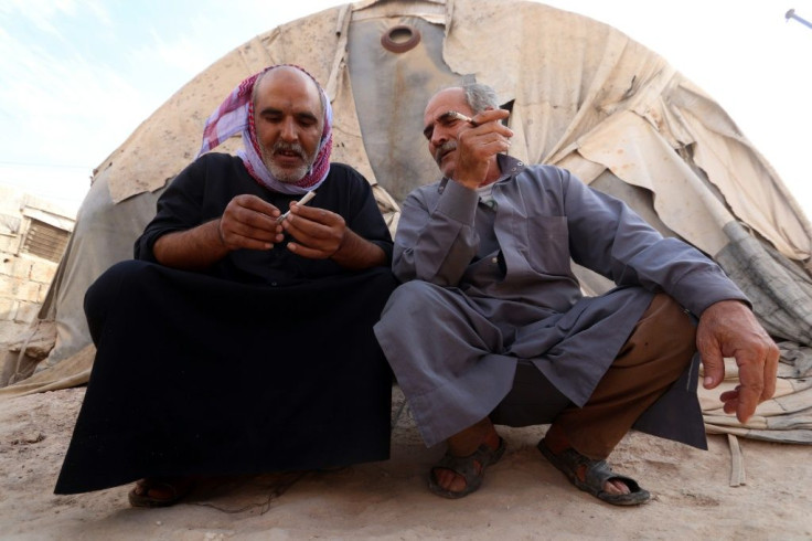 Displaced Syrian men in an overcrowded camp for the displaced near the village of Qah, near the border with Turkey