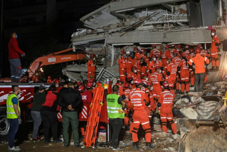 Rescuers search for survivors among the rubble of a collapsed building after a powerful earthquake struck Turkey's west coast and parts of Greece
