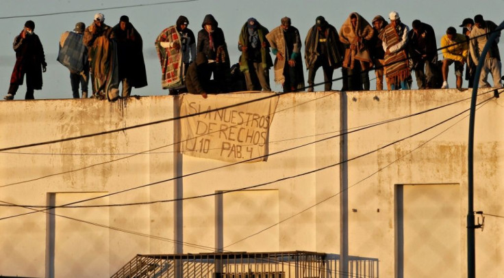 Prisoners stand on the roof of a prison in Melchor Romero in Argentina, with a banner reading "Yes to our rights", on October 31, 2020.