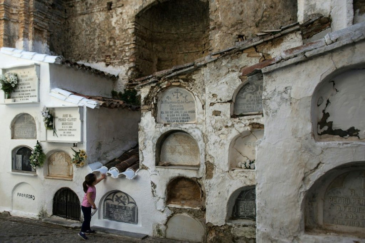 A girl touches a grave at Villaluenga del Rosario near Cadiz -- but amid spiking coronavirus cases authorities have urged Spaniards to space out All Saints Day visits to pay respects