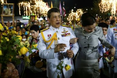 Thai King Maha Vajiralongkorn and Queen Suthida greet supporters as they leave the palace